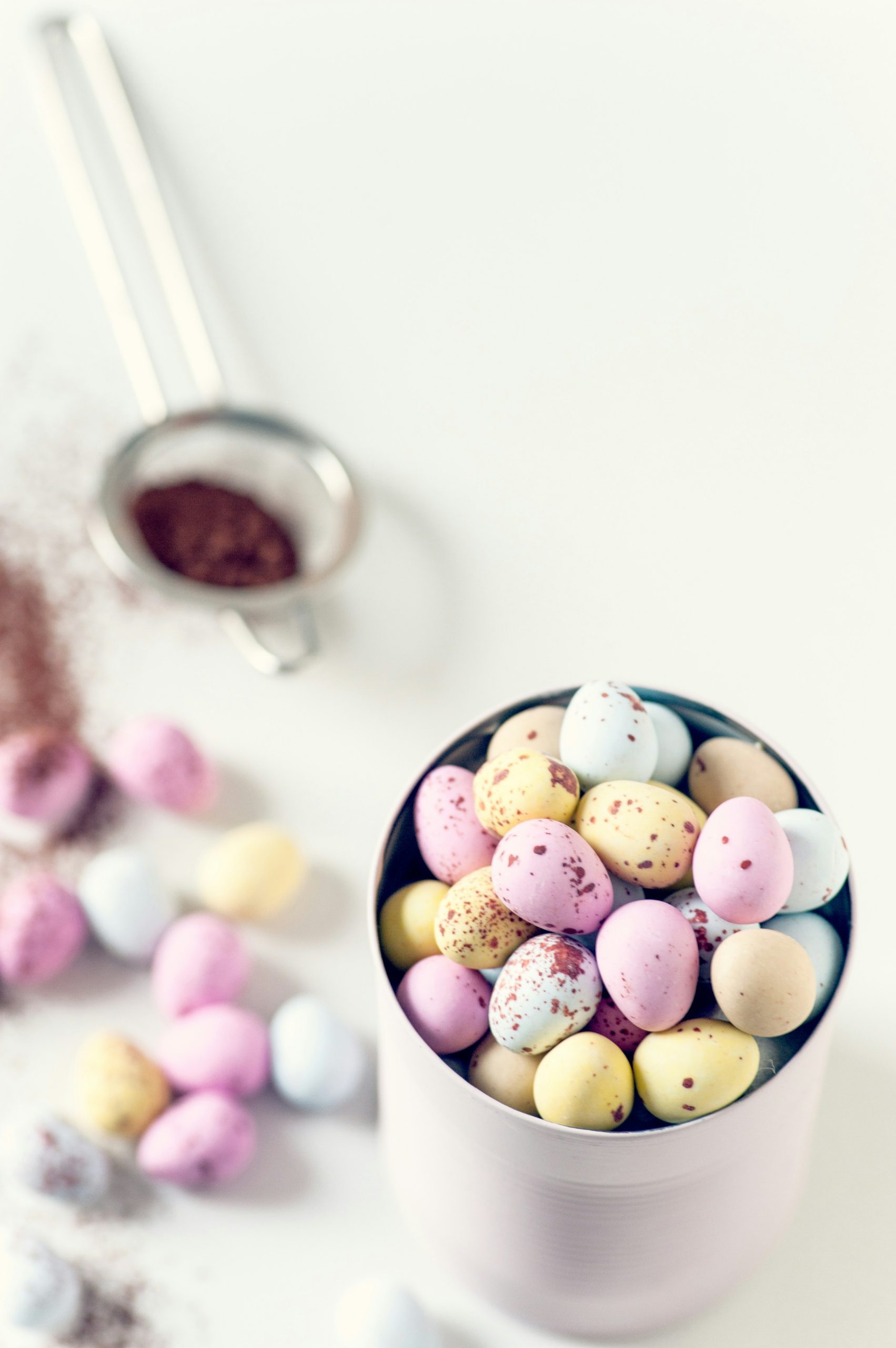 Tin of mini egg chocolates with some more eggs on the table in the background