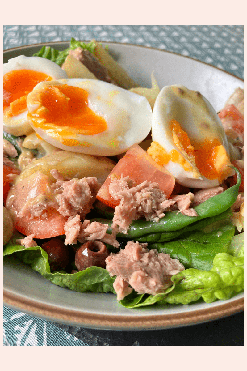 A colourful salad containing boiled eggs, tuna flakes and leafy greens to showcase a meal created from this recipe.